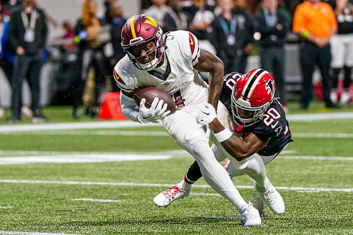 Washington Commanders wide receiver Curtis Samuel (4) runs through Atlanta Falcons cornerback Dee Alford (20) for a touchdown during the first half at Mercedes-Benz Stadium.